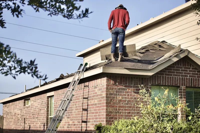 Professional roofer working on a residential roof in Water Mill